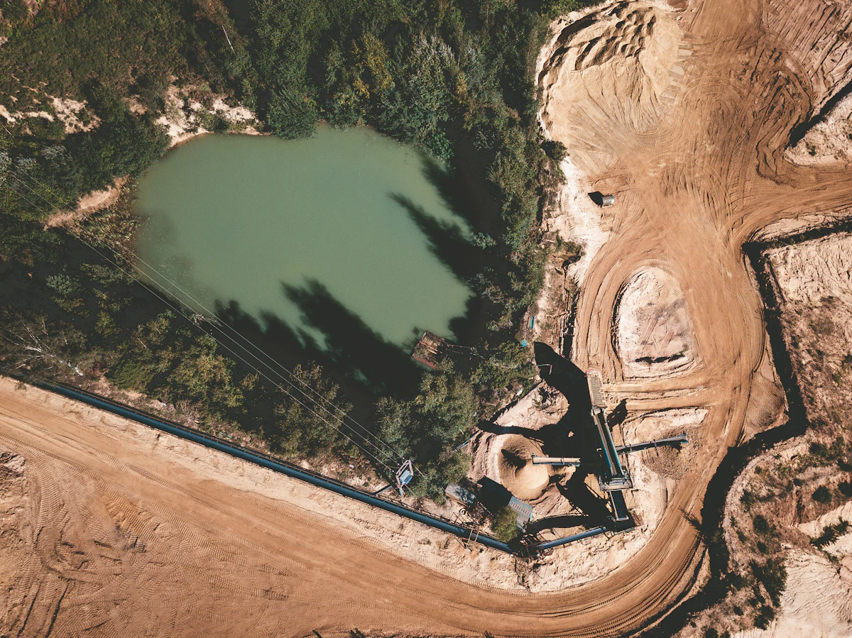 Aerial view of mining operation with groundwater monitoring wells in foreground