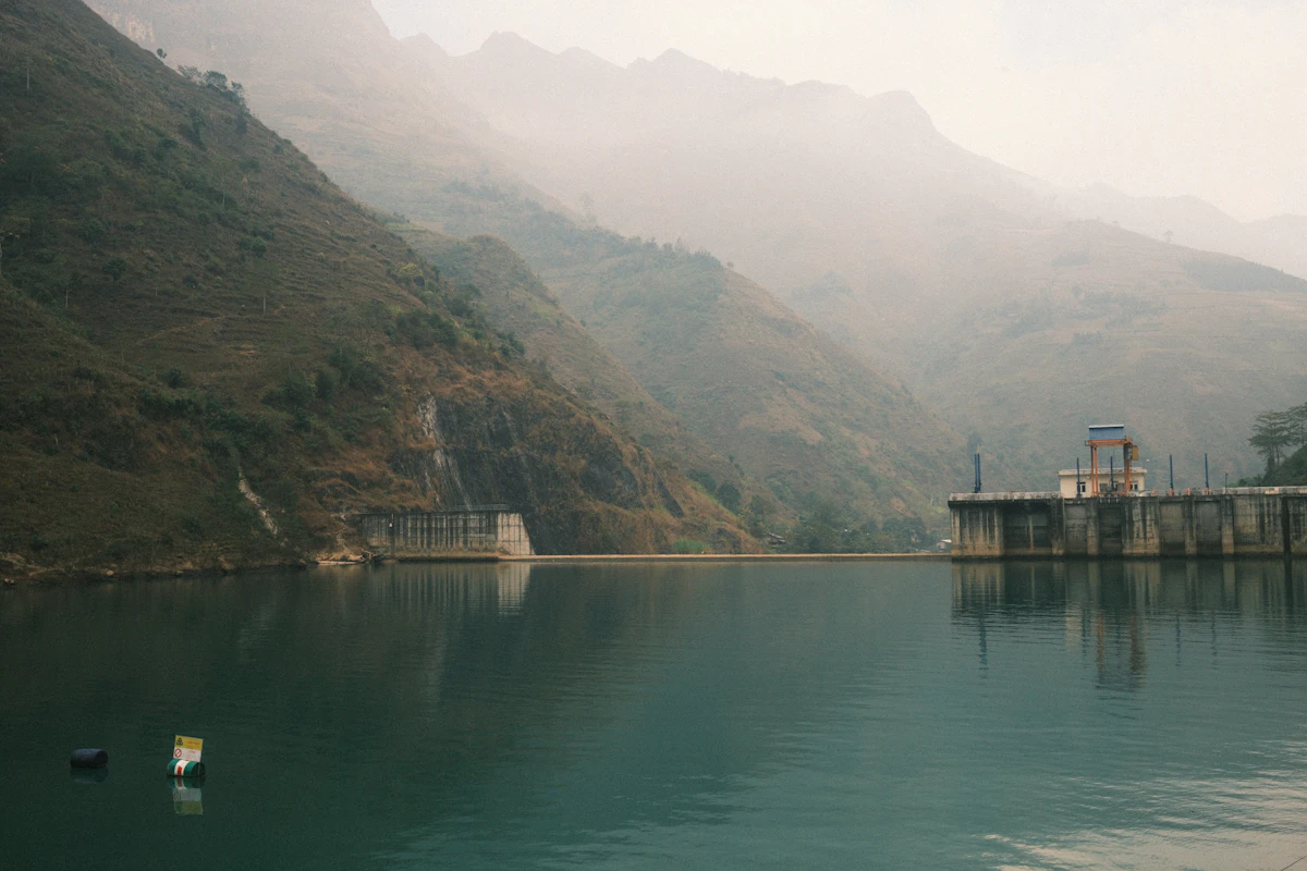 Municipal water intake structure on a river surrounded by agricultural land, early morning