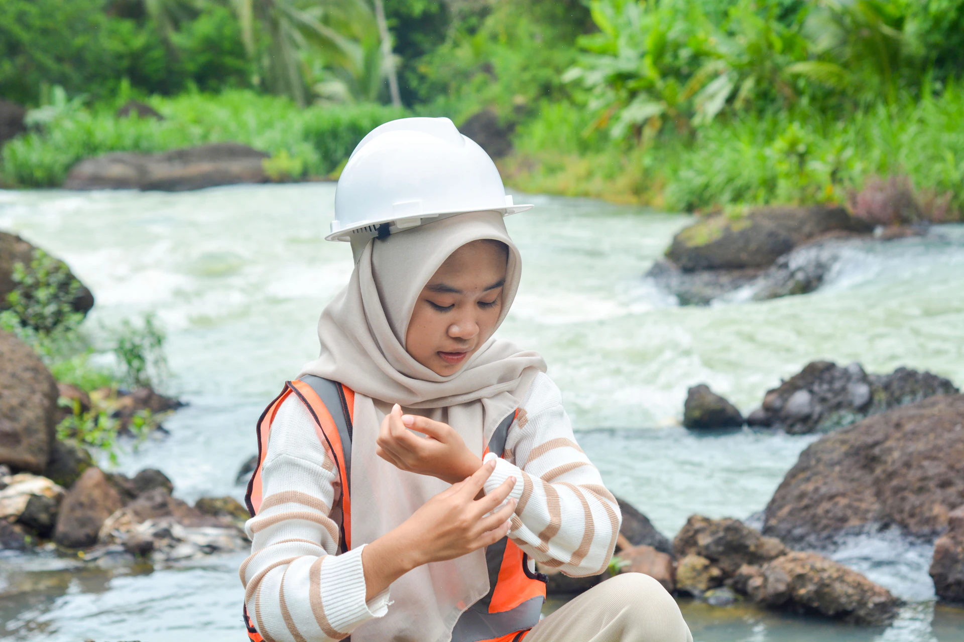 Environmental field team deploying monitoring equipment along a river bank at sunrise